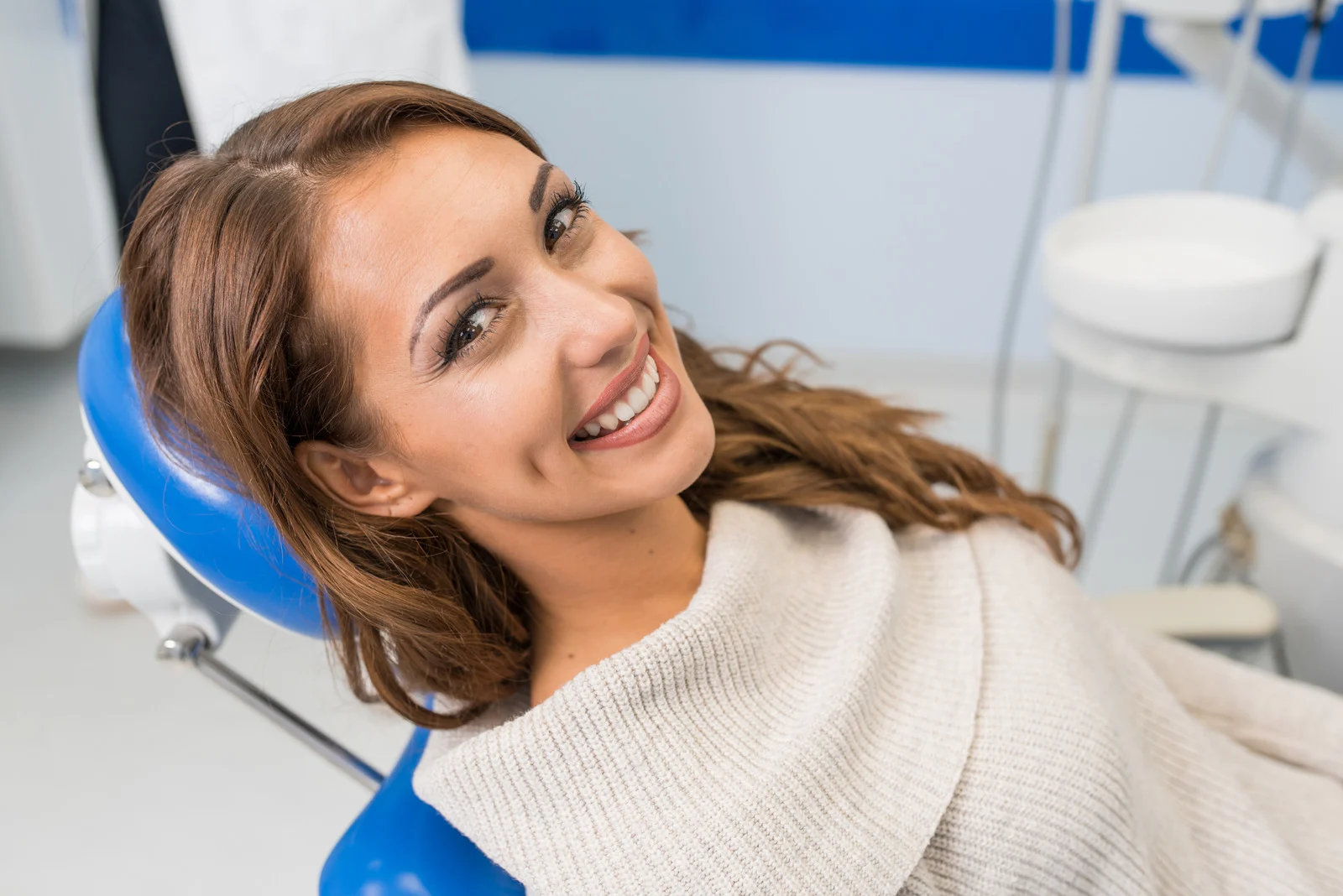 Happy patient woman in a examination chair at the dentist's office